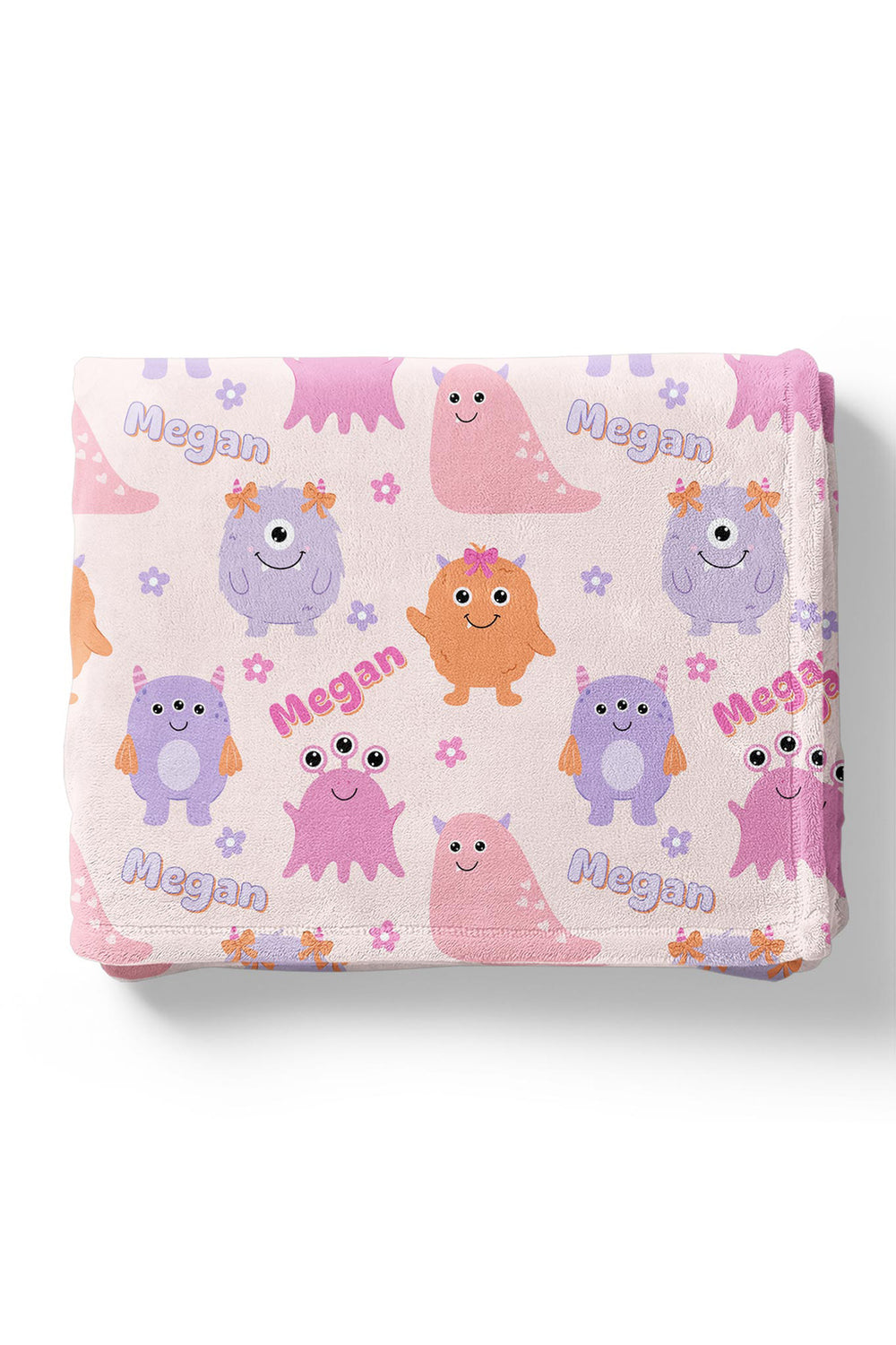 Folded Caden Lane personalized "Megan" minky blanket in Little Monsters print with pink, purple, and orange cartoon monsters and flowers