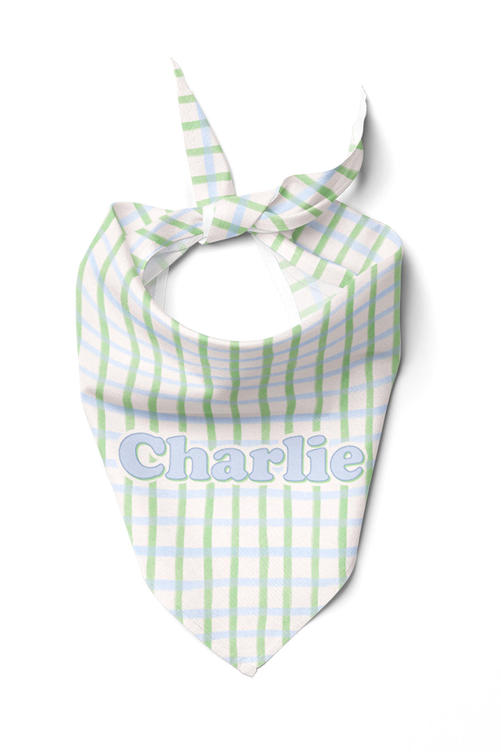 Personalized pet bandana in green and blue picnic plaid, tied in a knot and shown from the front with the name "Charlie" embroidered on the front panel