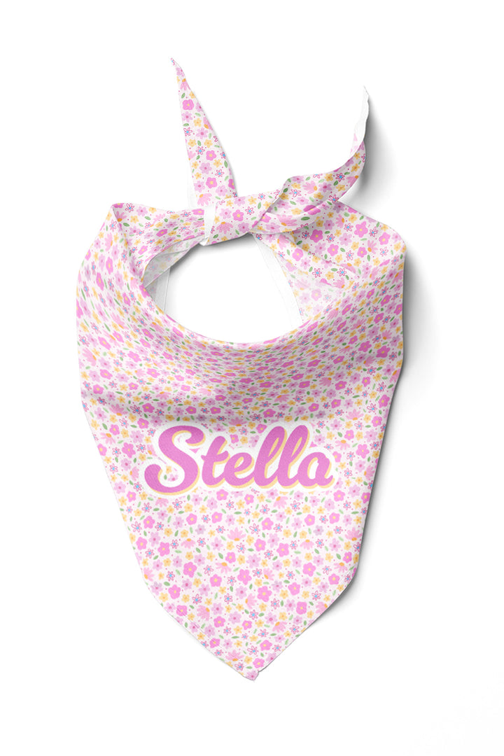 Personalized pet bandana tied in a knot, featuring the Scattered Blooms print with pink, purple, and yellow flowers on white, with pet name in pink script lettering
