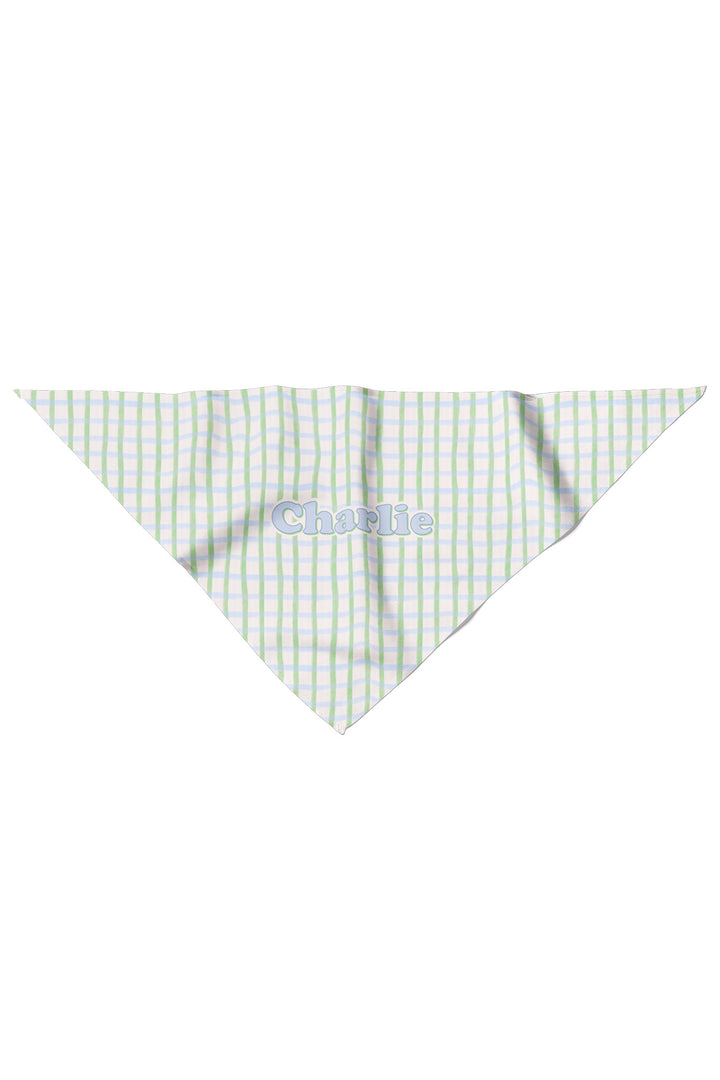 Flat lay of a personalized pet bandana in green and blue picnic plaid, shown as a triangle with the name "Charlie" personalized on the front