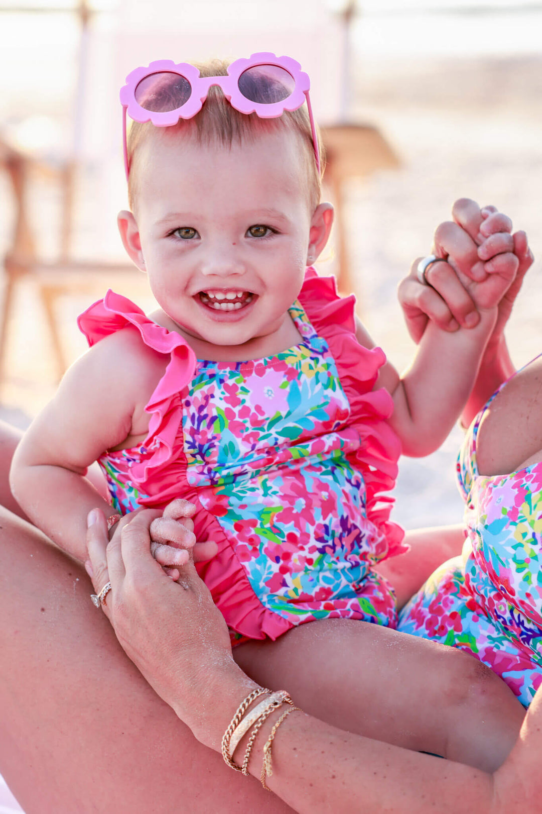 baby girl sitting on mom's lap in petal splash double ruffle one piece