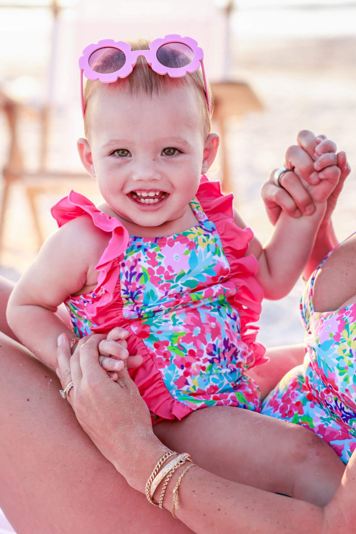 baby girl sitting on mom's lap in petal splash double ruffle one piece