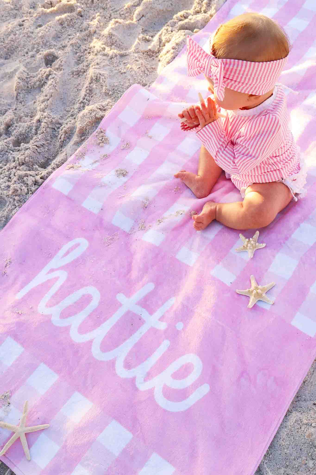 girl sitting on pink seersucker personalized towel 