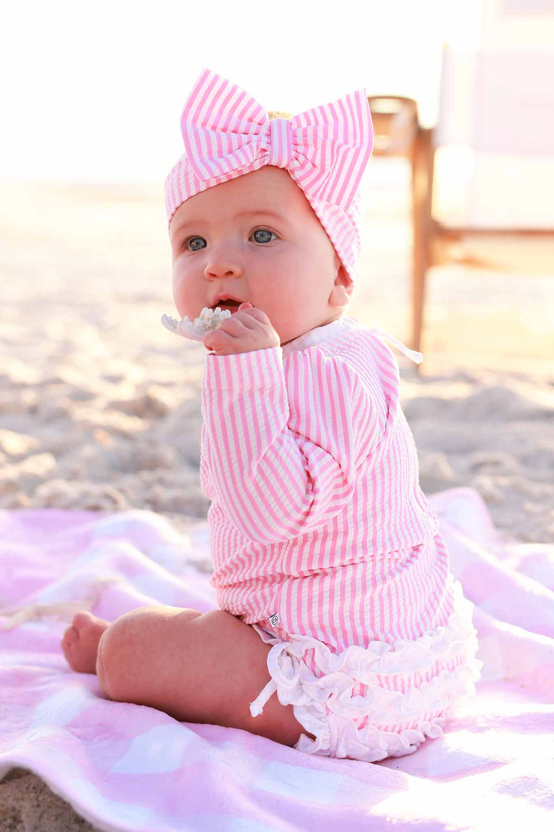 side view of pink seersucker rash guard ruffle bottom swimsuit for baby girls 