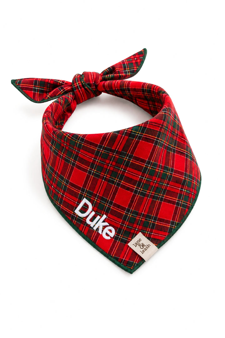 Tired back Lane & Leash personalized dog bandana in red tartan plaid with dark green edge trim, embroidered with the name 'Duke' in white