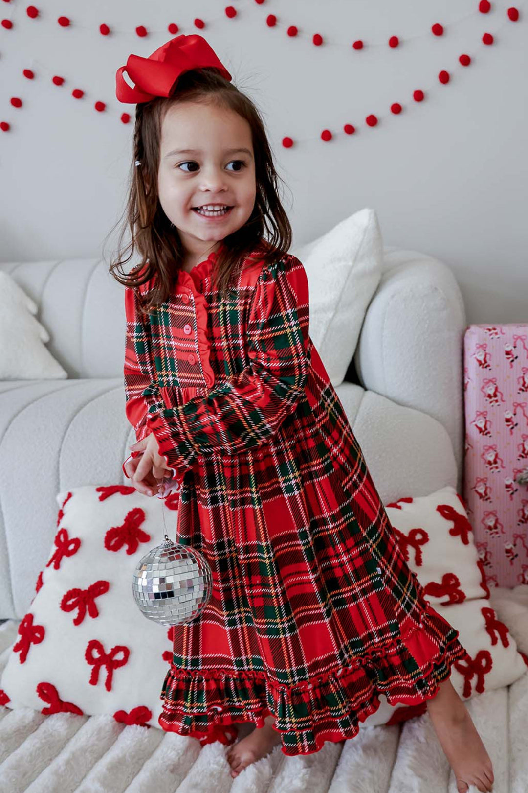 Little girl wearing a Caden Lane Christmas bamboo plaid dress in a classic red and green tartan print, styled for festive holiday parties, family photos, and Christmas celebrations.