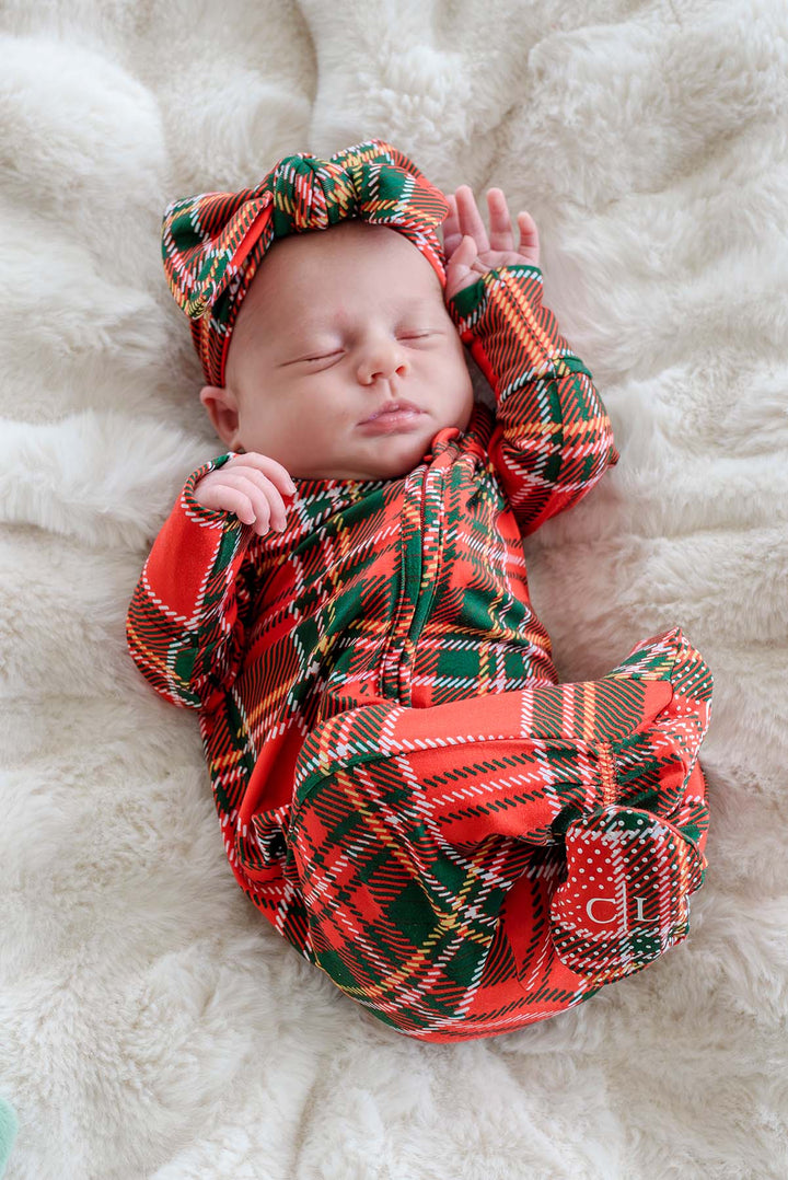 Caden Lane Christmas bamboo convertible zipper footie in a classic red and green plaid print with matching oversized bow headwrap, cozy newborn holiday pajamas for baby's first Christmas.
