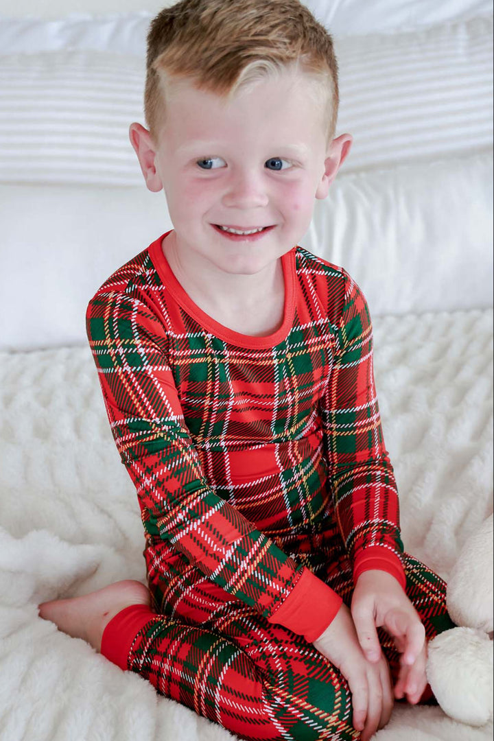 Caden Lane child wearing Christmas bamboo two-piece pajamas in a classic red and green plaid print, featuring ultra-soft matching holiday sleepwear for boys and kids.