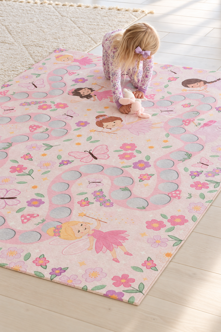 Young girl playing on a personalized Caden Lane fairy garden kids’ rug decorated with magical fairies, butterflies, flowers and winding paths.