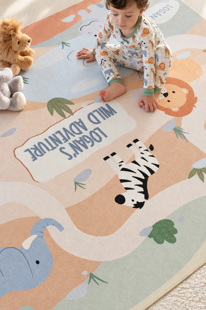 Toddler playing on a personalized Caden Lane wild safari playroom rug featuring a zebra, lion, elephant and winding path.