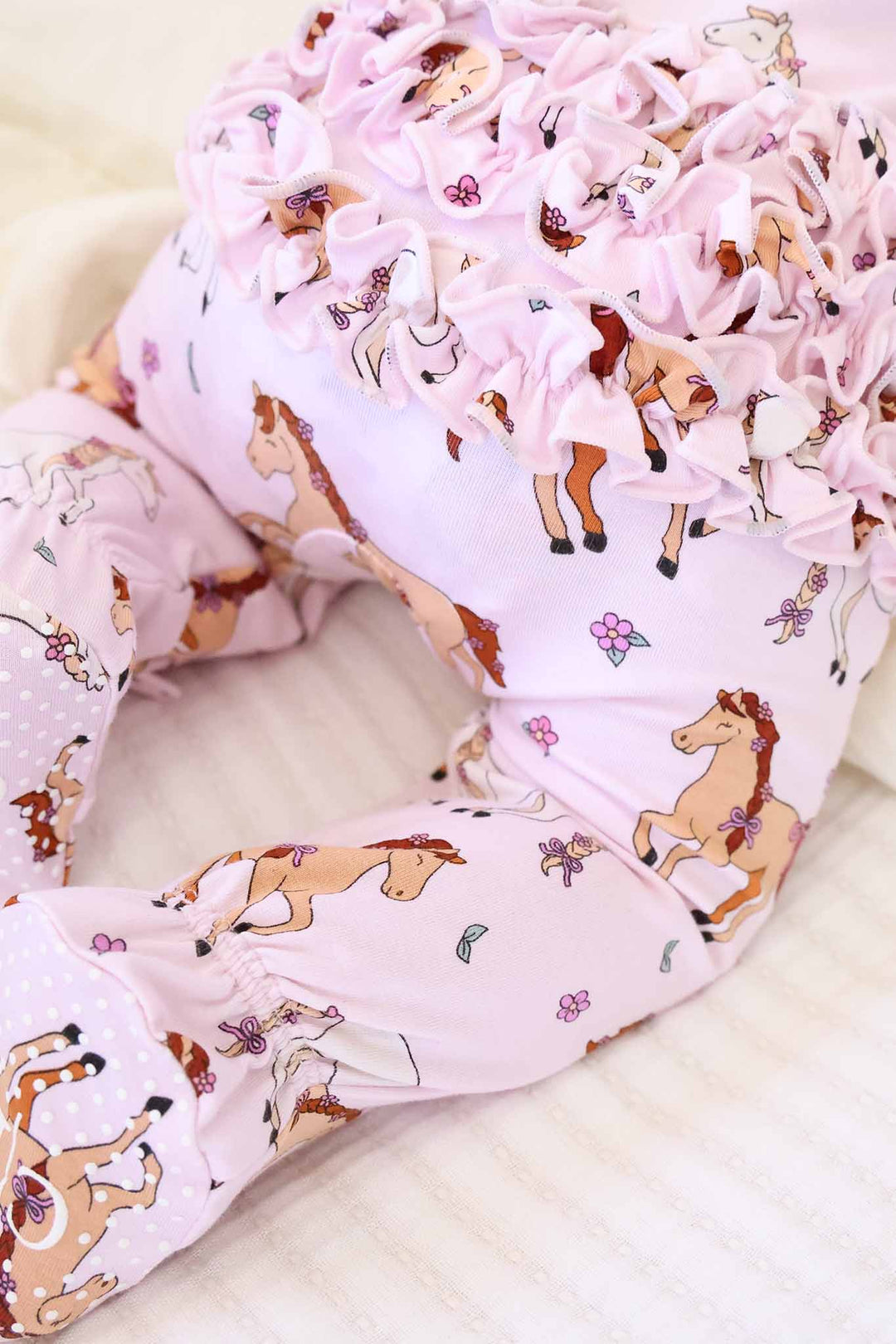 ruffle bottom zipper footie for girls with pink pony print 