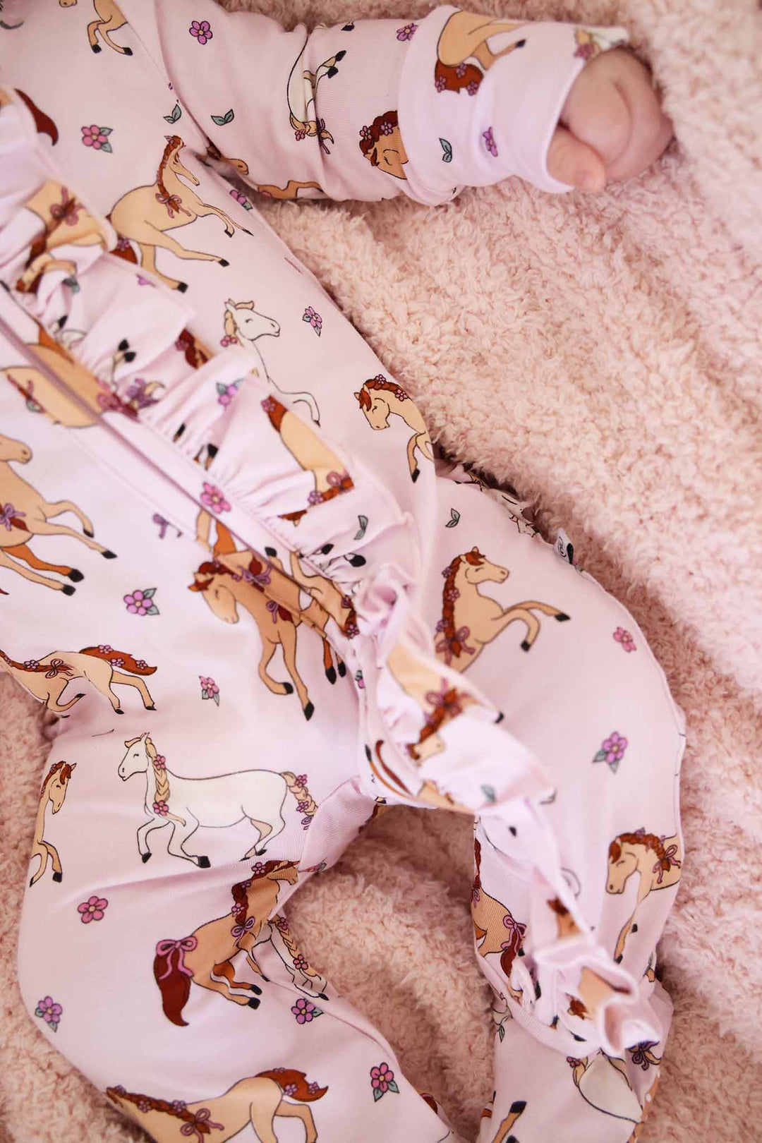closeup of pony club pink ruffle zipper footie 
