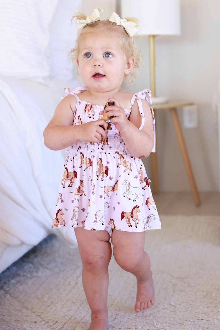 toddler girl walking wearing pony club pink spaghetti strap smocked skirt bodysuit 