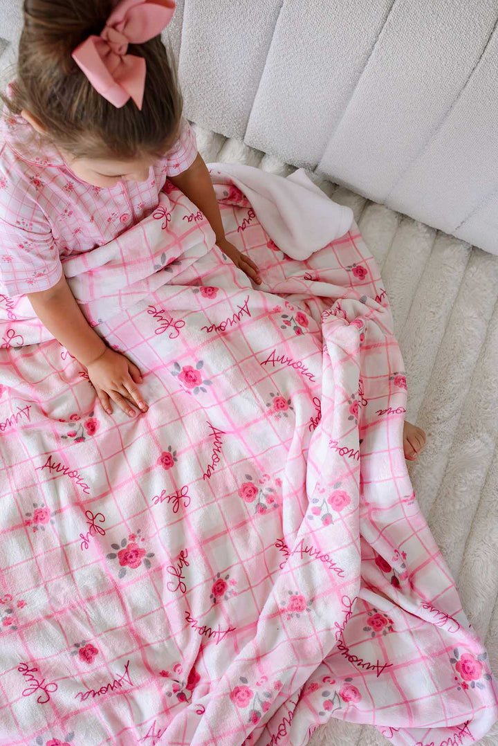 Girl wrapped in personalized Primrose Plaid kids blanket in bed