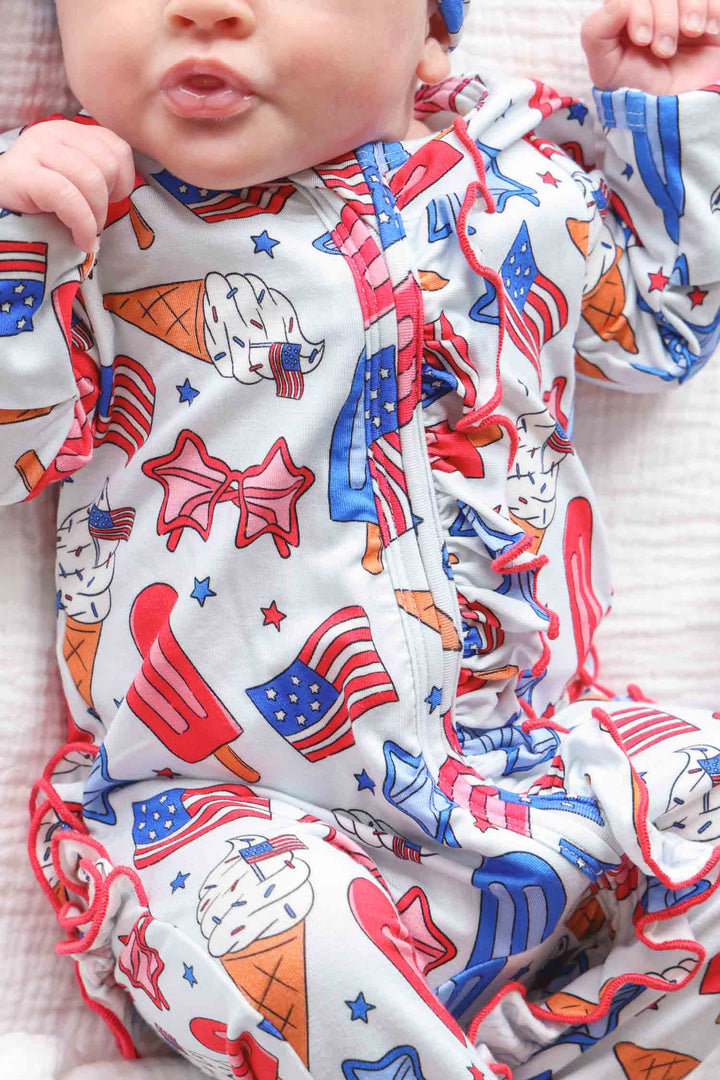 caden lane red white and cool ruffle zipper footie on model - 4th of july bamboo patriotic baby
