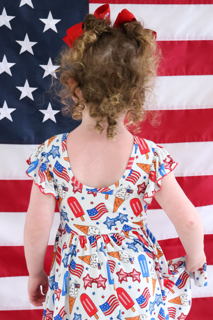 caden lane red white and cool ruffle twirl dress on model - 4th of july patriotic toddler girl