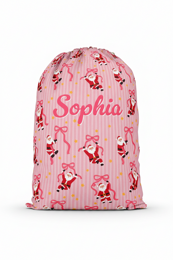 Personalized Caden Lane Jolly Ribbons Christmas Santa Sack featuring a custom name, festive pink stripes, whimsical Santa print, and ribbon design for Christmas gifts and holiday traditions.
