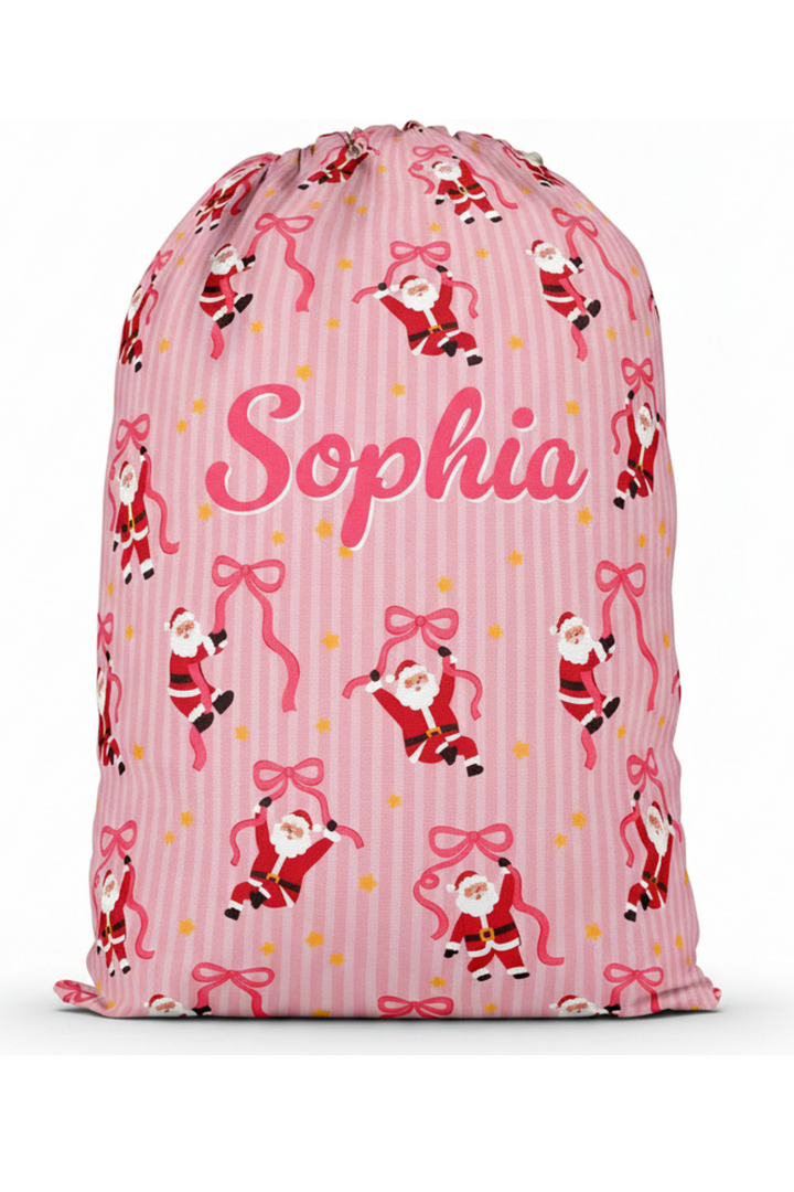 Personalized Caden Lane Jolly Ribbons Christmas Santa Sack featuring a custom name, festive pink stripes, whimsical Santa print, and ribbon design for Christmas gifts and holiday traditions.