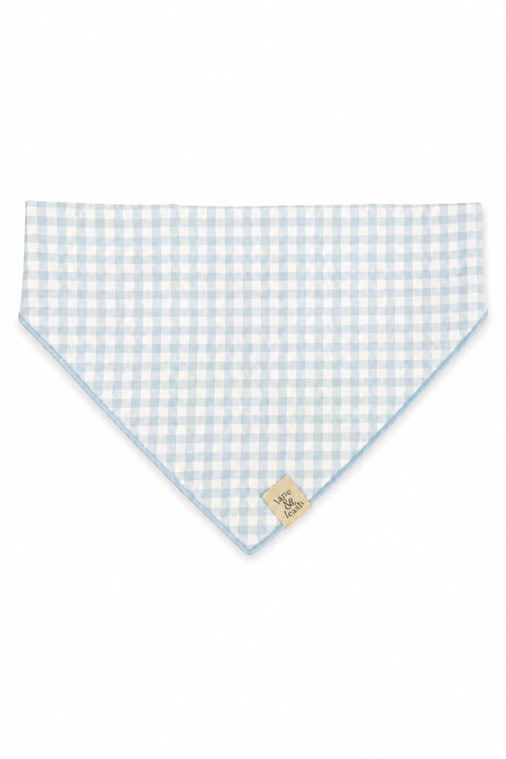 A Lane & Leash light blue and white gingham checkered pet bandana with a small beige brand tag, displayed flat against a white background.