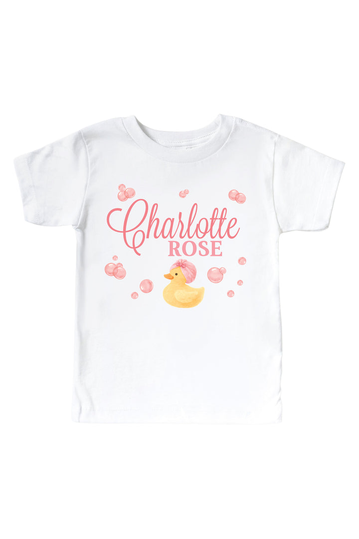White kids t-shirt with personalized pink bubble duckie graphic featuring yellow rubber duck, pink bubbles, and custom name on front