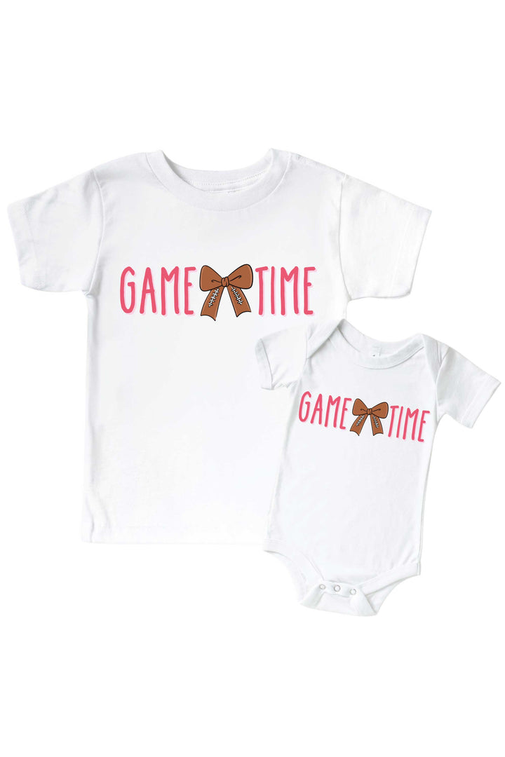 Caden Lane Graphic Bodysuit & Kids' Tee, Game Time Pink — matching toddler-and-baby t-shirt set in white, featuring a "Game Time" graphic with a football-patterned bow.
