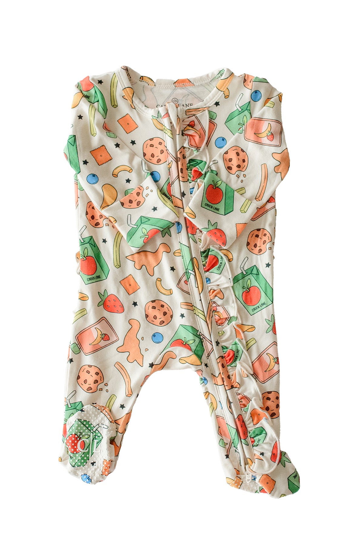Flat lay of the Snack Attack Ruffle Bamboo Zipper Footie on a white background, showing the full one-piece footie with ruffle details, the colorful snack print featuring cookies, juice cartons, dinosaur crackers, and strawberries, with a front zipper closure