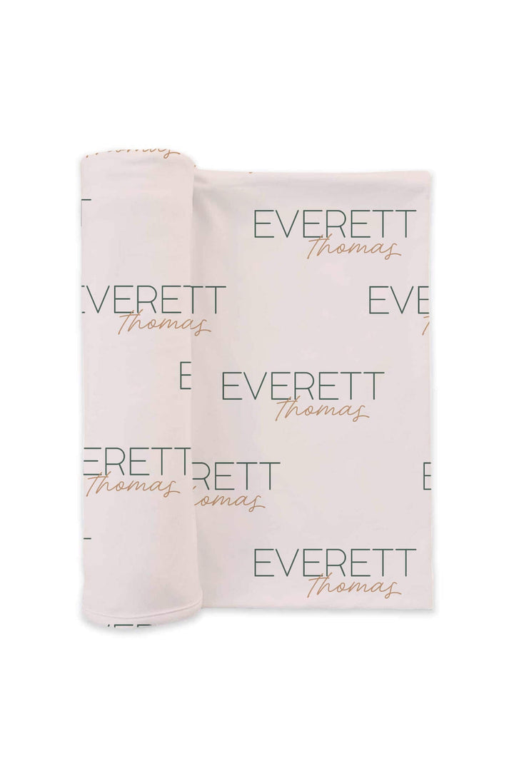 neutral personalized swaddle blanket with green and gold font 