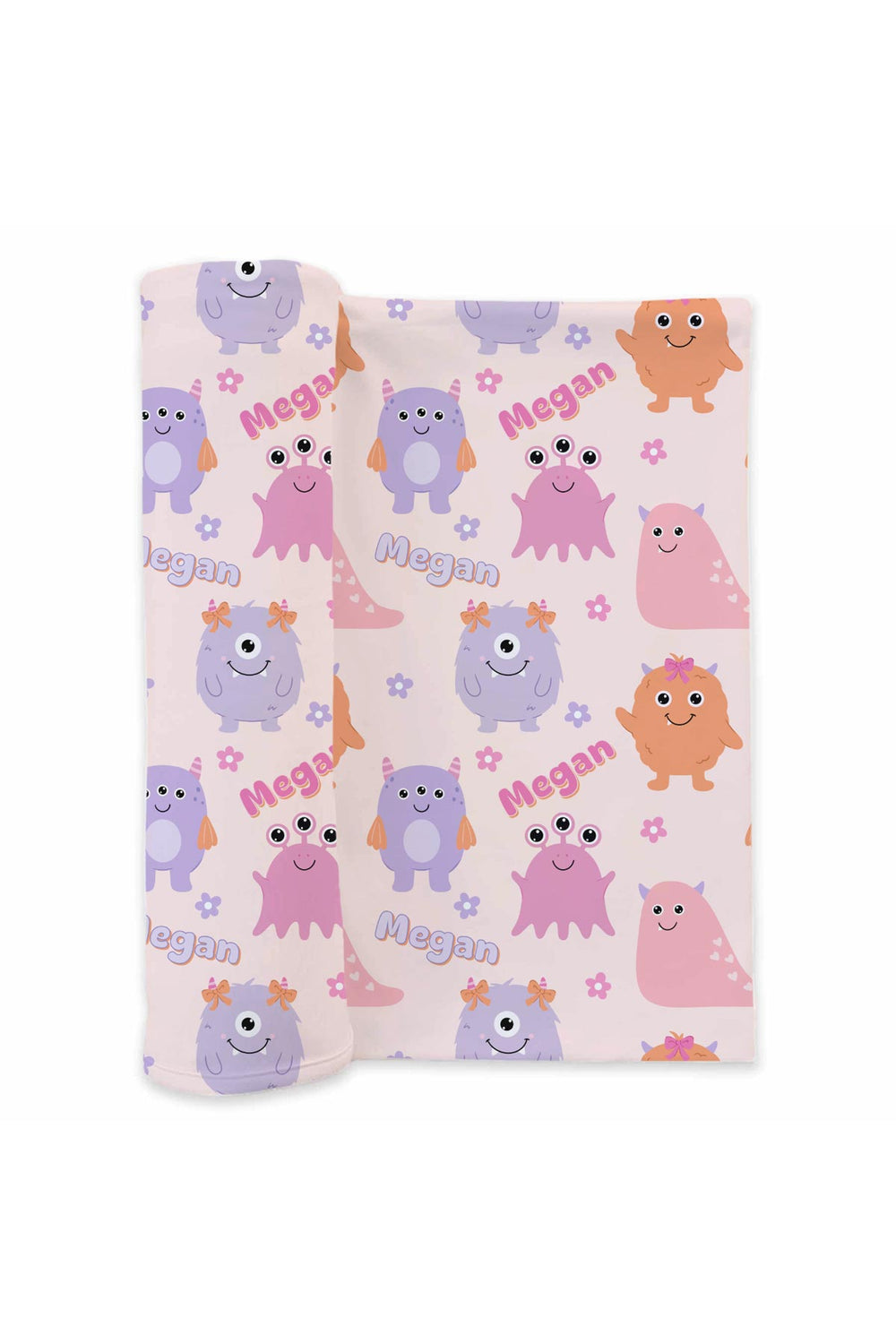 Product shot of Caden Lane personalized "Megan" swaddle blanket rolled out, showing Little Monsters print with pink, purple, and orange cartoon monsters and flowers on a blush background