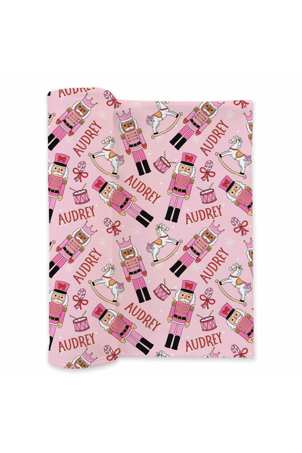 Personalized Caden Lane Christmas blanket featuring pink nutcrackers, rocking horses, drums, bows, snowflakes, and a custom child’s name.