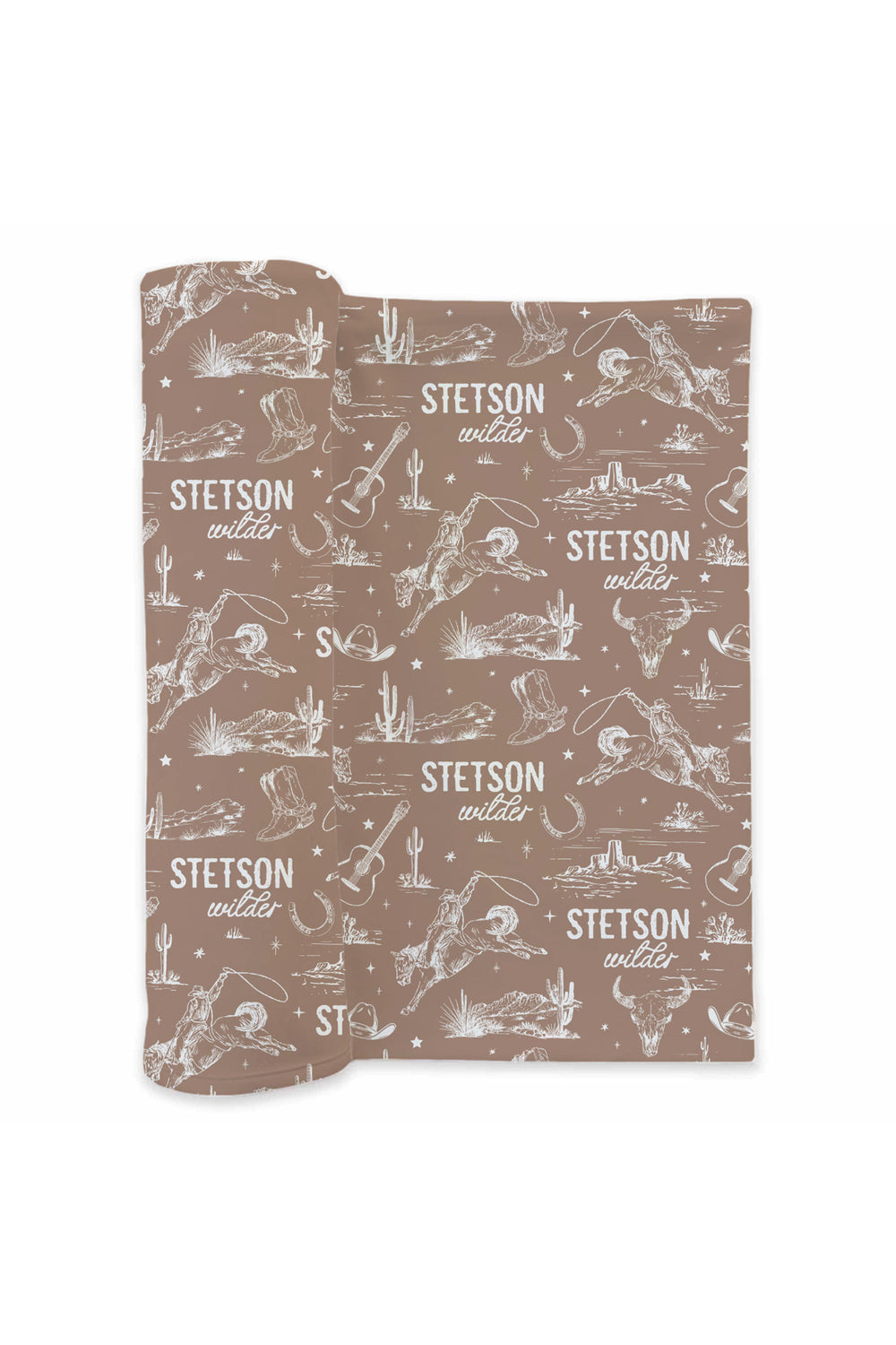 Flat lay of a partially unrolled Caden Lane brown knit swaddle in a Wild West Toile print featuring cowboys, guitars, cacti, and longhorn skulls, reading "Stetson Wilder."