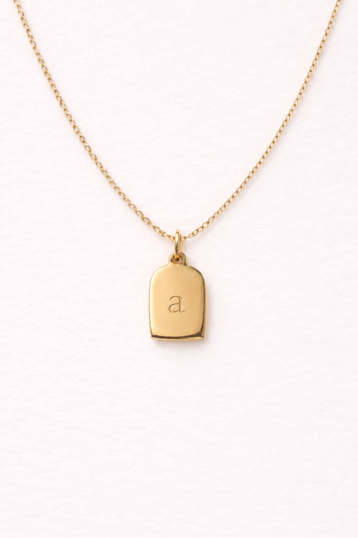 Caden Lane gold necklace with engraved lowercase script initial "a" tag charm pendant