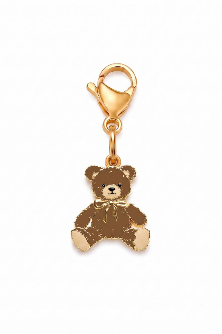 A Lane & Leash gold-plated charm shaped like a teddy bear, featuring brown enamel detailing and a small gold bow, set against a plain white background.