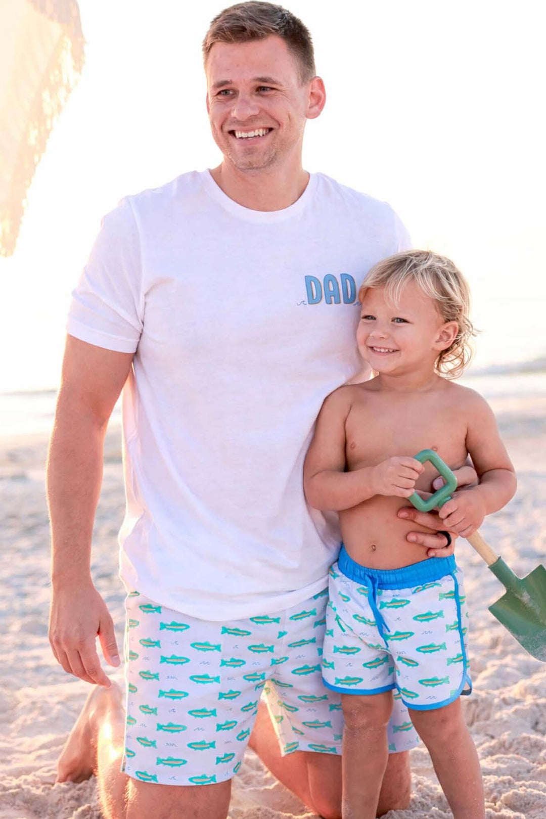dad and son on the beach in tiny trout matching swim trunks 
