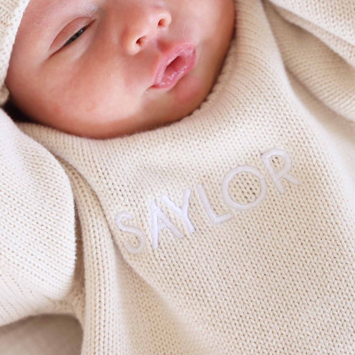 light tan embroidered long sleeve sweater romper with white thread