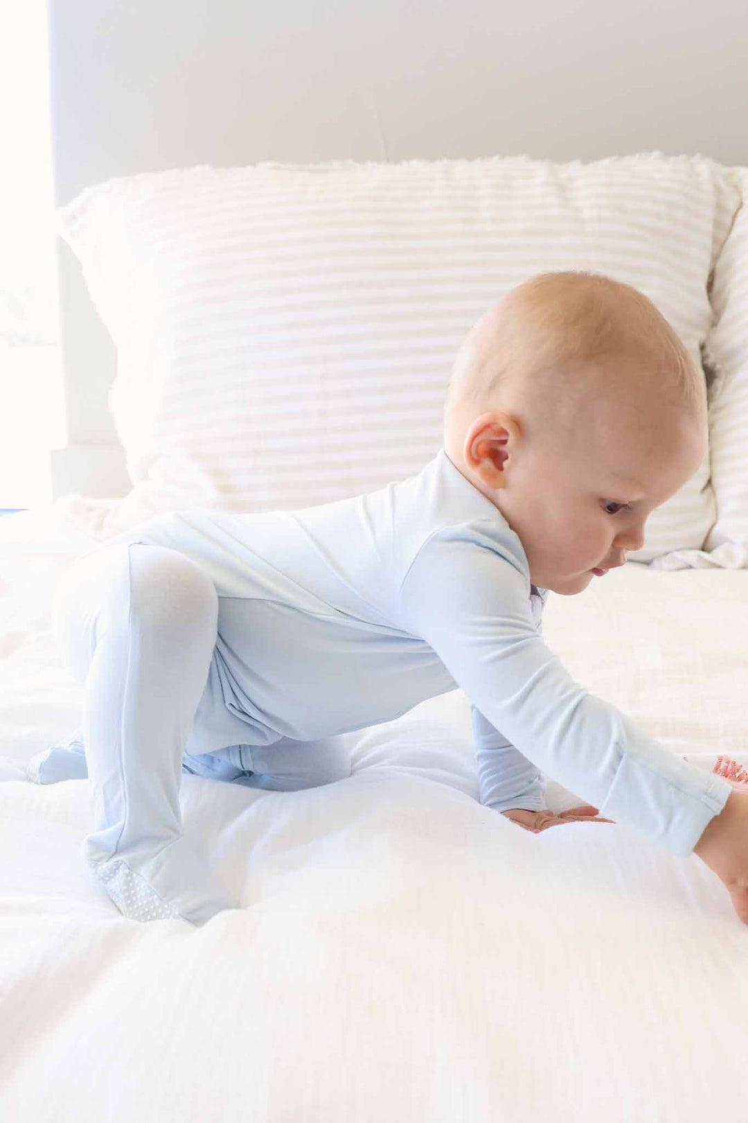 crawling baby boy in light blue long sleeve zipper footie pajama 