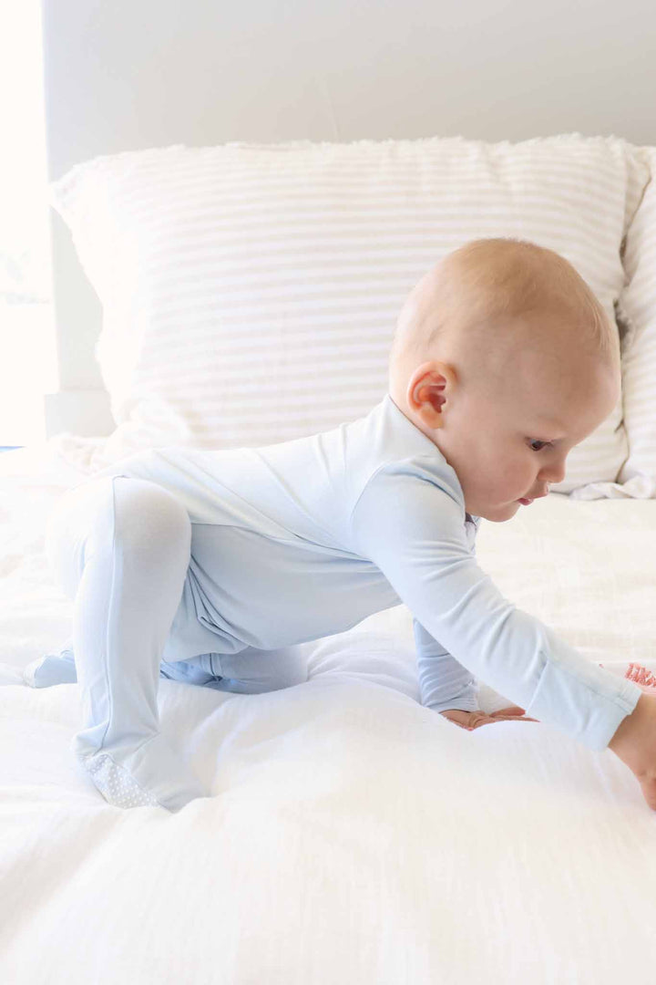 crawling baby boy in light blue long sleeve zipper footie pajama 