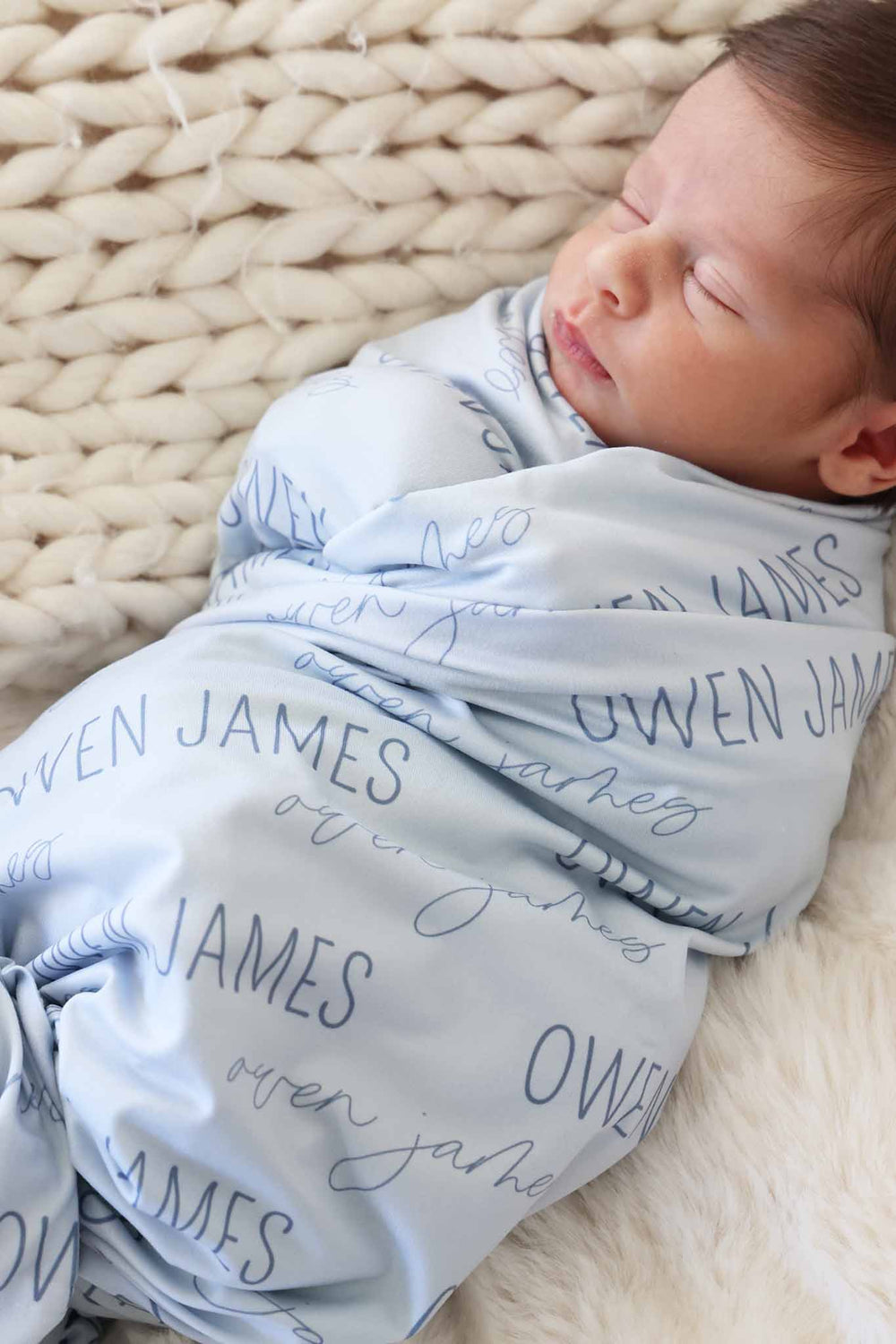 closeup of block and script font personalized blue swaddle blanket for boys 
