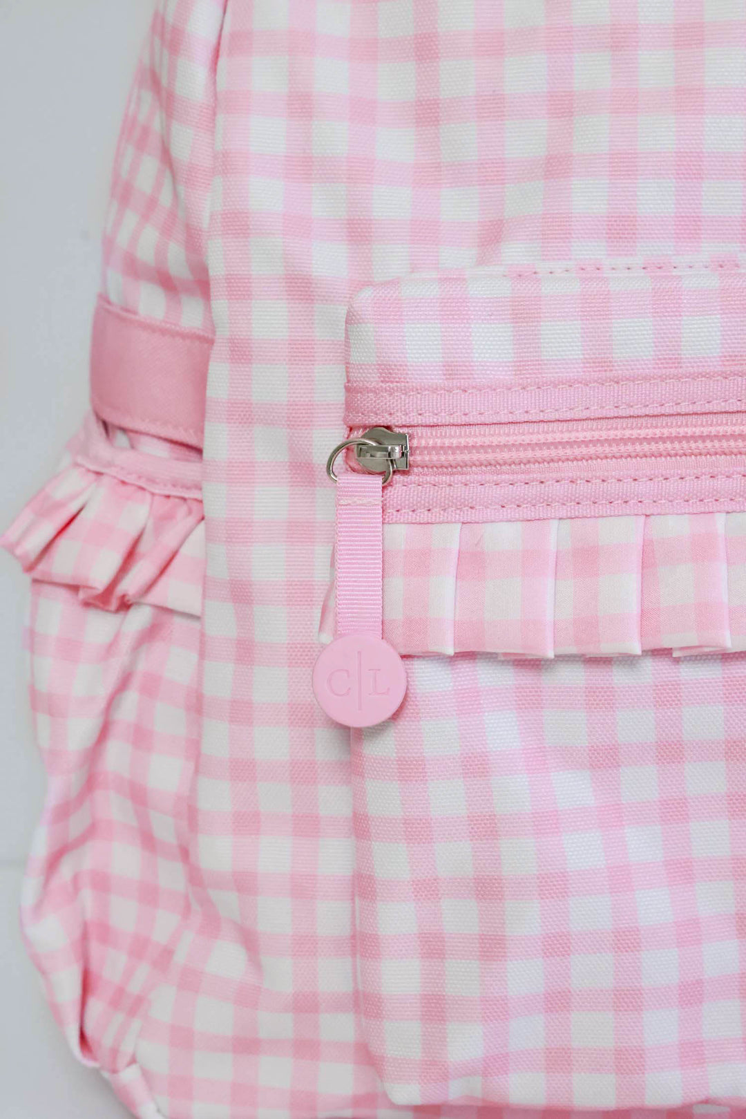 closeup of zipper on pink gingham embroidered backpack 