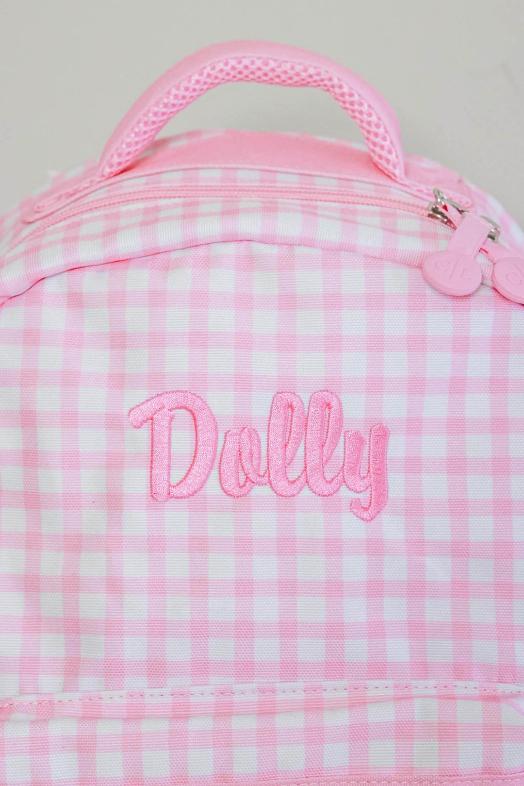 closeup of embroidery on pink gingham backpack 