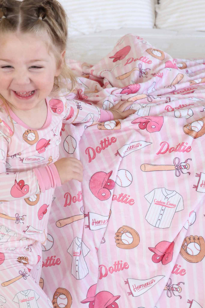older girl leaning on ballpark babes personalized blanket wearing a matching pajama set