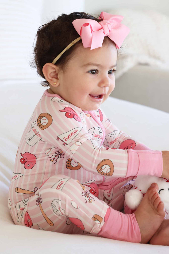 side view of ballpark babes pink convertible zip romper for girls with matching candy pink ribbon bow headband 