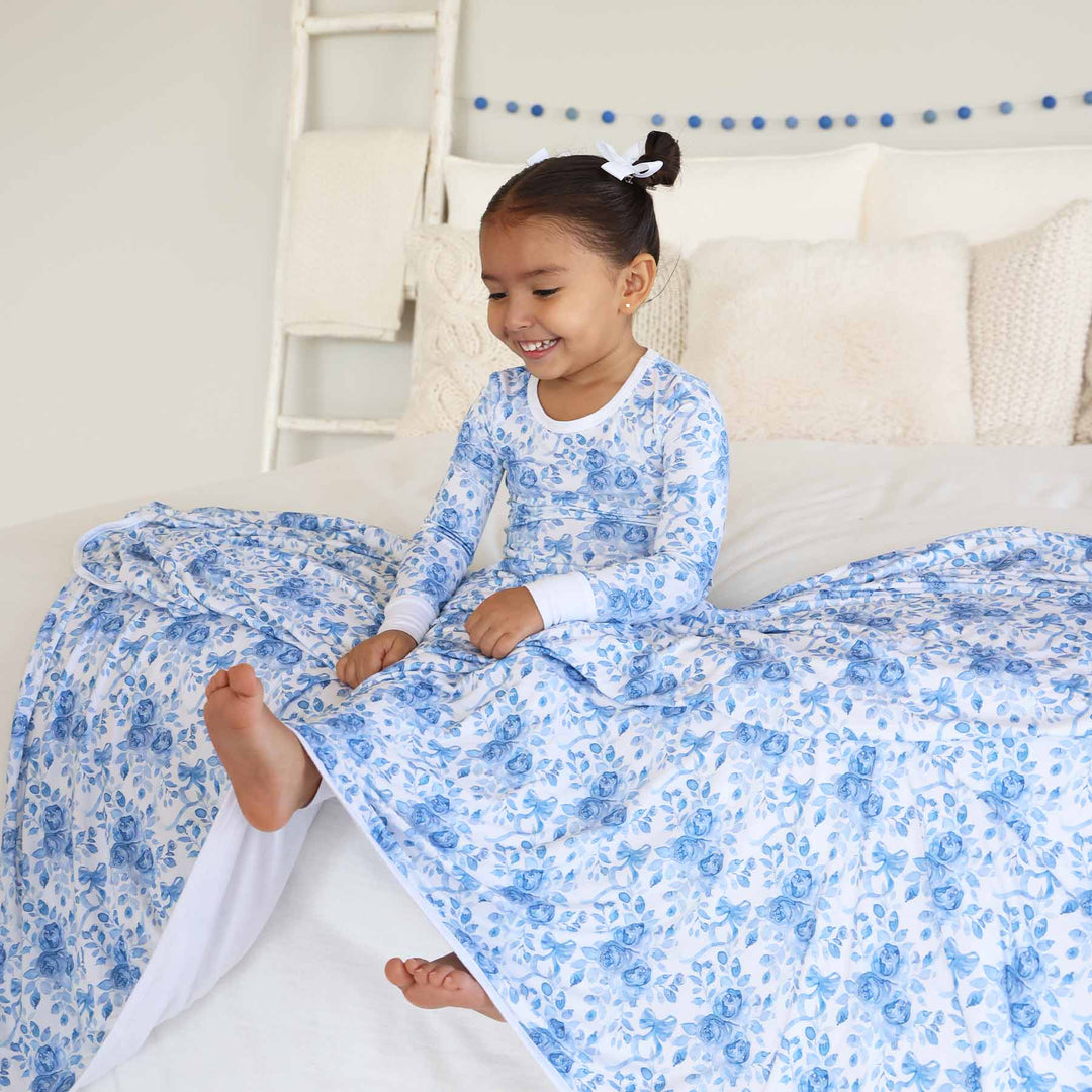 girl wearing betsy's blooms two piece pajama set with matching bamboo blanket on the lap