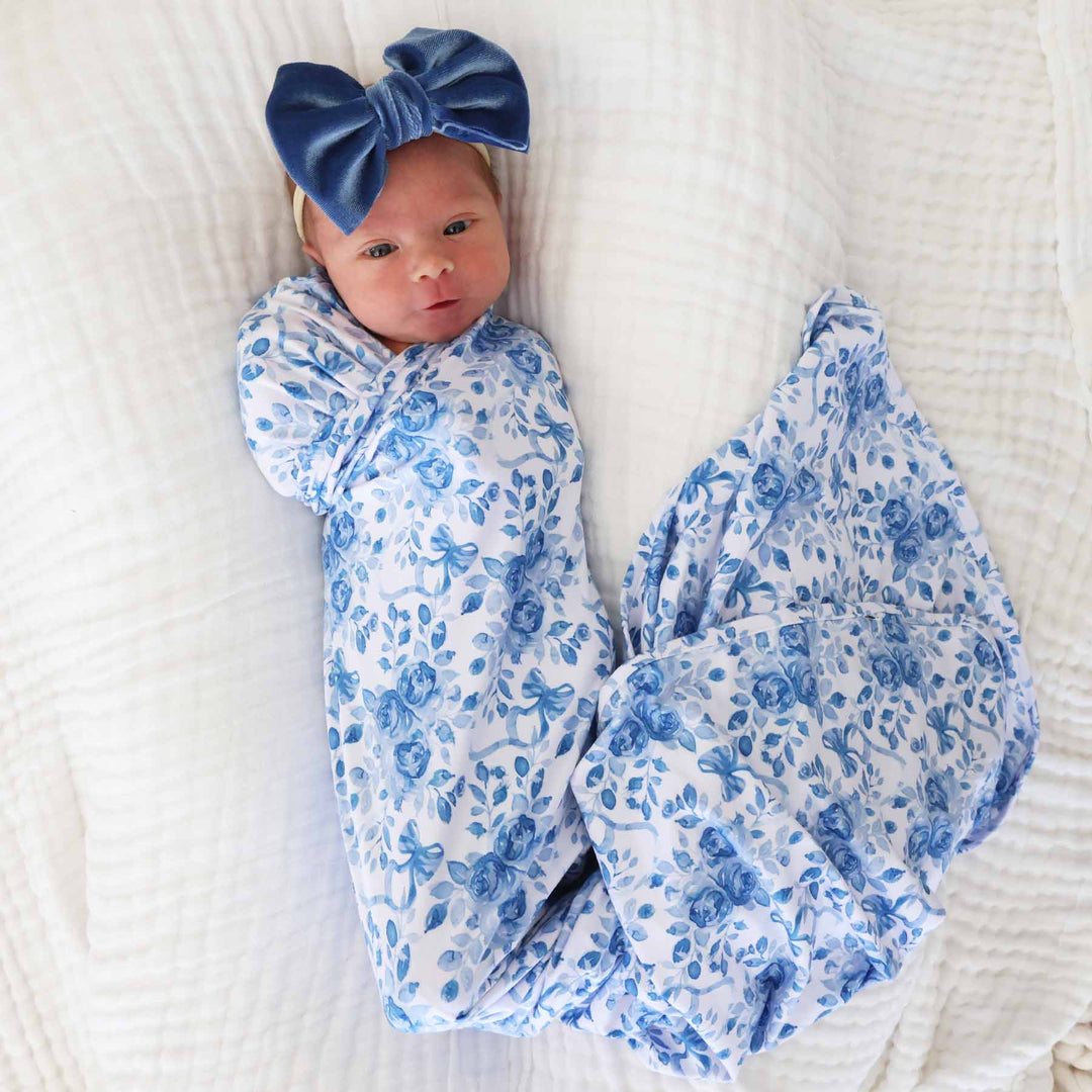 baby wrapped in blue floral and bow oversized swaddle blanket with blue velvet bow headband 