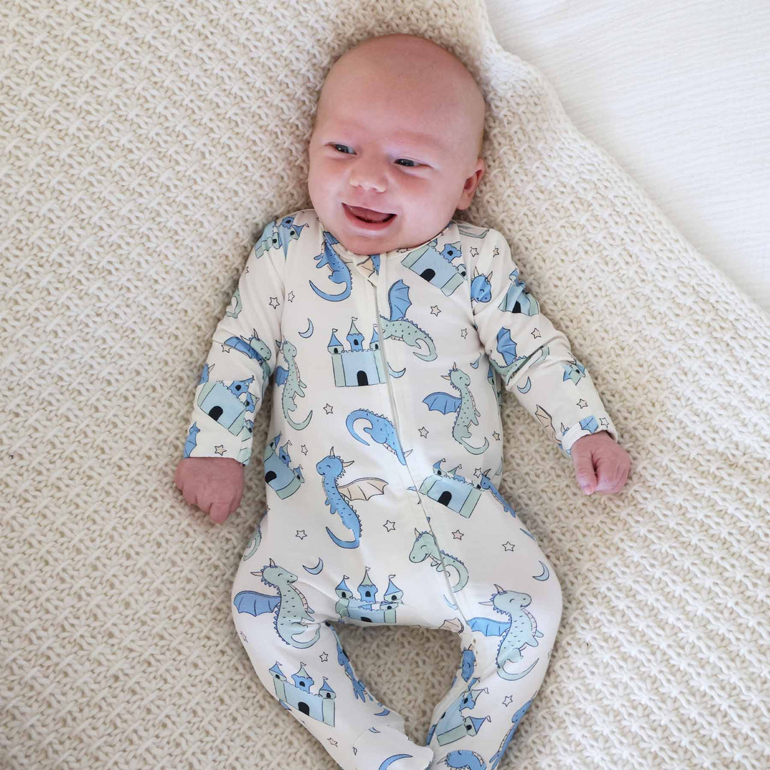 Baby outfit featuring blue and sage green dragons on cream fabric