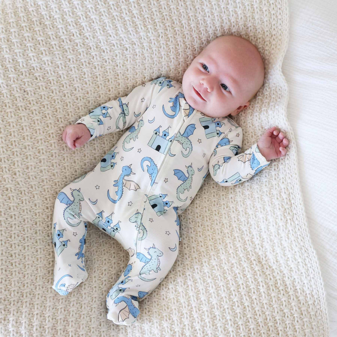 Baby in fantasy-inspired footie with dragon and castle artwork