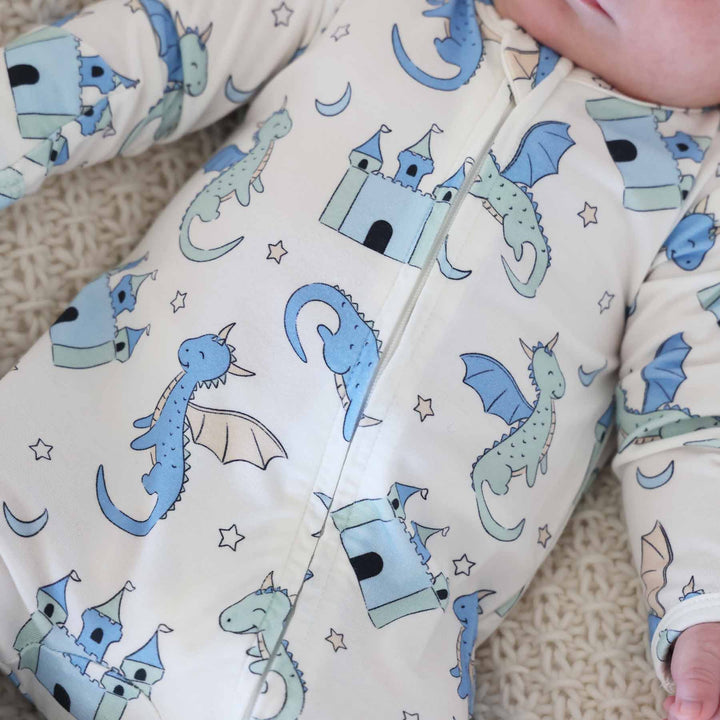 Newborn in dragon and castle print zip-up onesie
