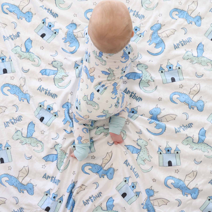 baby wearing pastel dragon and castle convertible zip romper pajama crawling on matching personalized blanket 