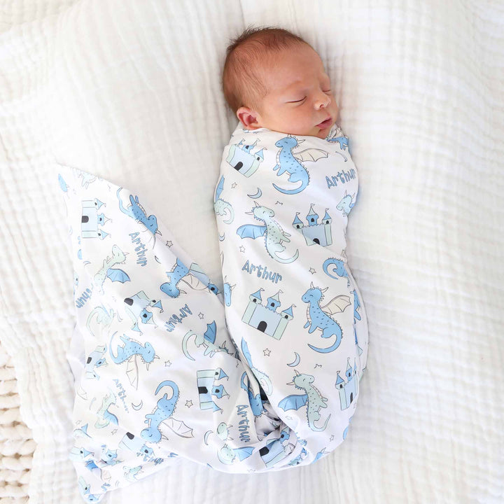 newborn boy wrapped in dragon and castle swaddle blanket personalized with name 