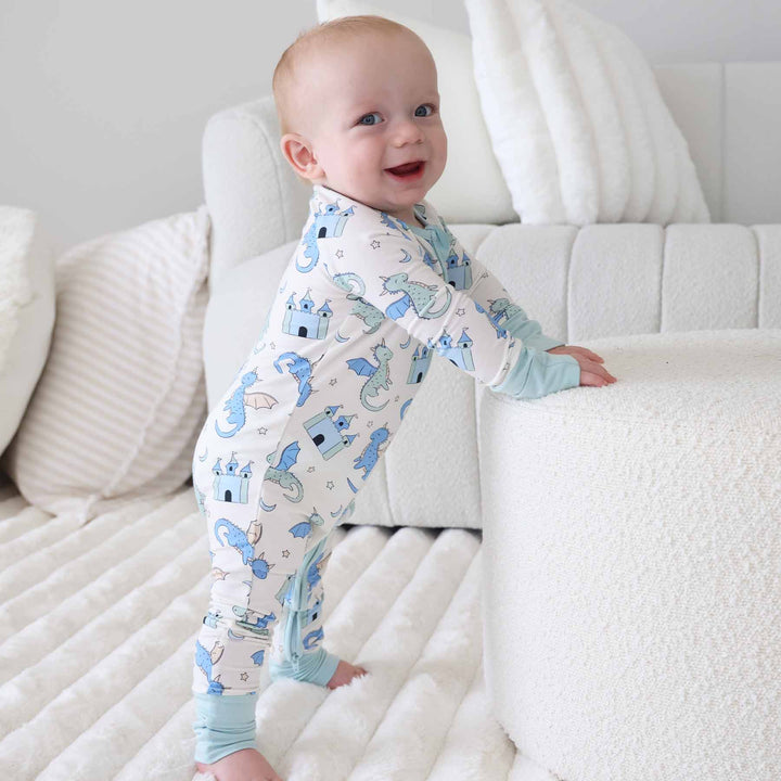 Baby standing in dragon and castle convertible zip romper with mint cuffs