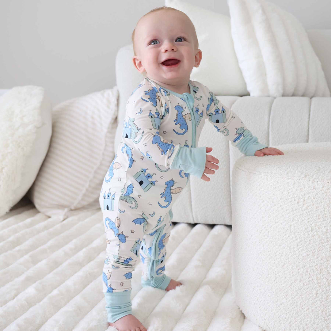 Infant dressed in whimsical dragon print convertible zip sleeper